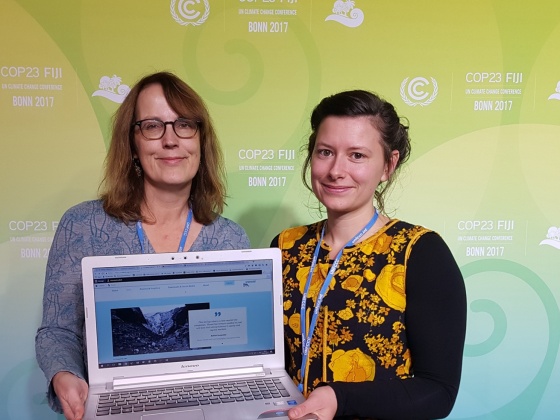 two women holding a laptop showing the GCEL website